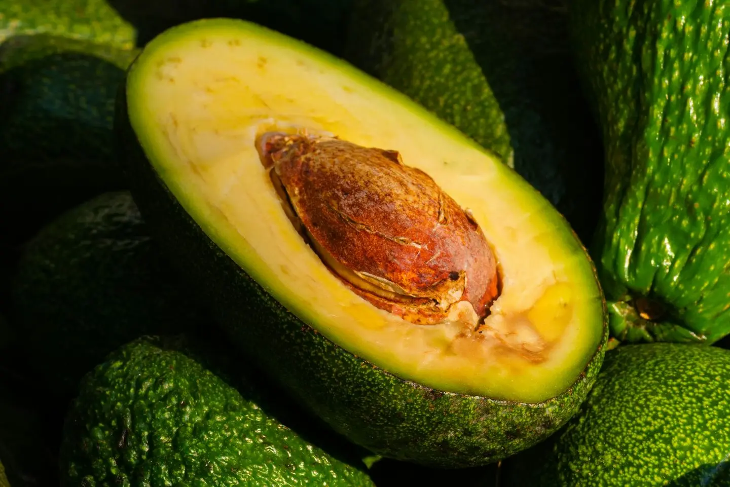 a pile of green avocados sitting on top of each other